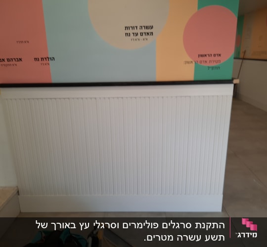 קיר עם לוח עץ לבן וכלי עבודה על הרצפה